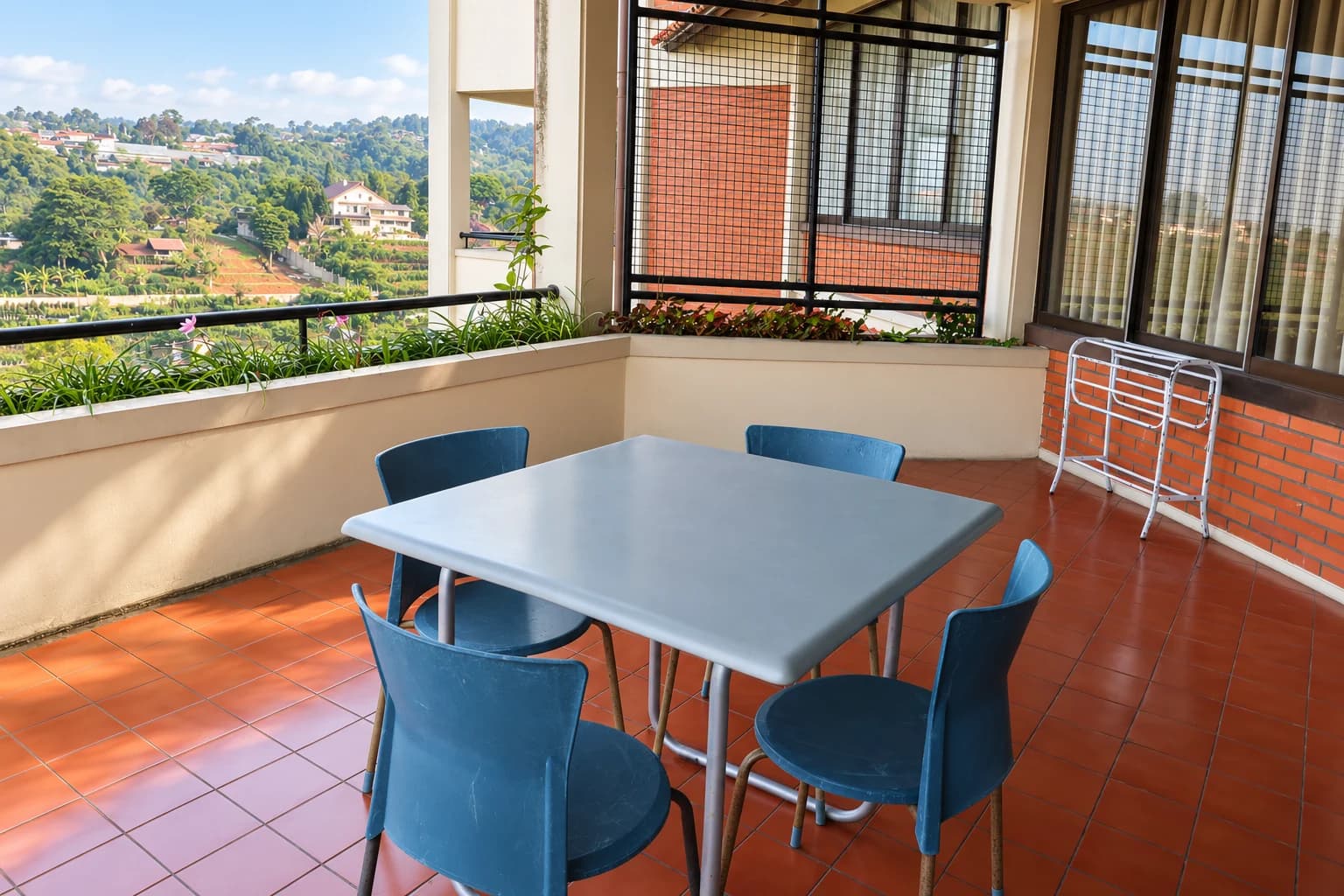 AI-edited photo of a Villa 3 balcony with a gray table, four blue chairs and valley views