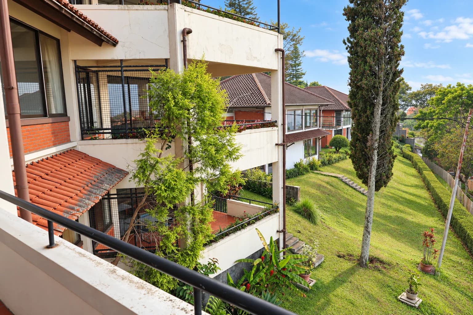 AI-edited photo of Villa 3’s side balconies beside a sloping lawn and tall trees